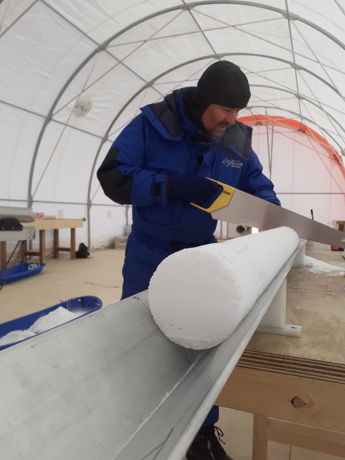 Gregory Teste, co-auteur de l'étude, découpe une carotte de glace antarctique à la station Concordia, en Antarctique. © Gregory Teste, Institut des Géosciences de l'Environnement